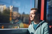 Ein junger Mann sitzt in der S-Bahn und schaut aus dem Fenster. Ein junger Mann sitzt in der S-Bahn und schaut aus dem Fenster.